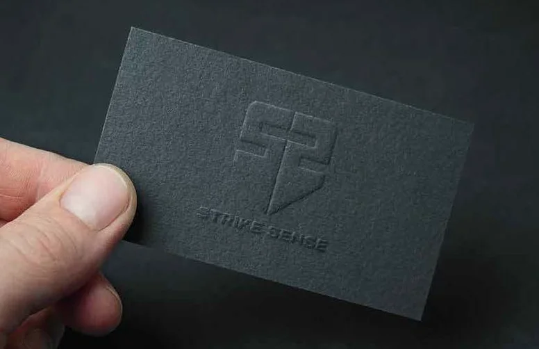 Strike Sense brandmark embossed on a dark business card